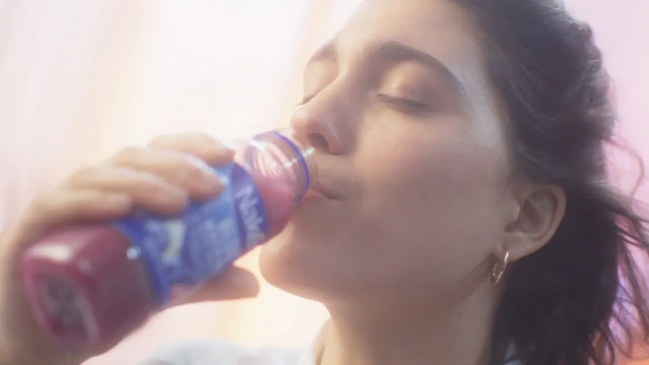 Drinking a Naked smoothie, eyes closed